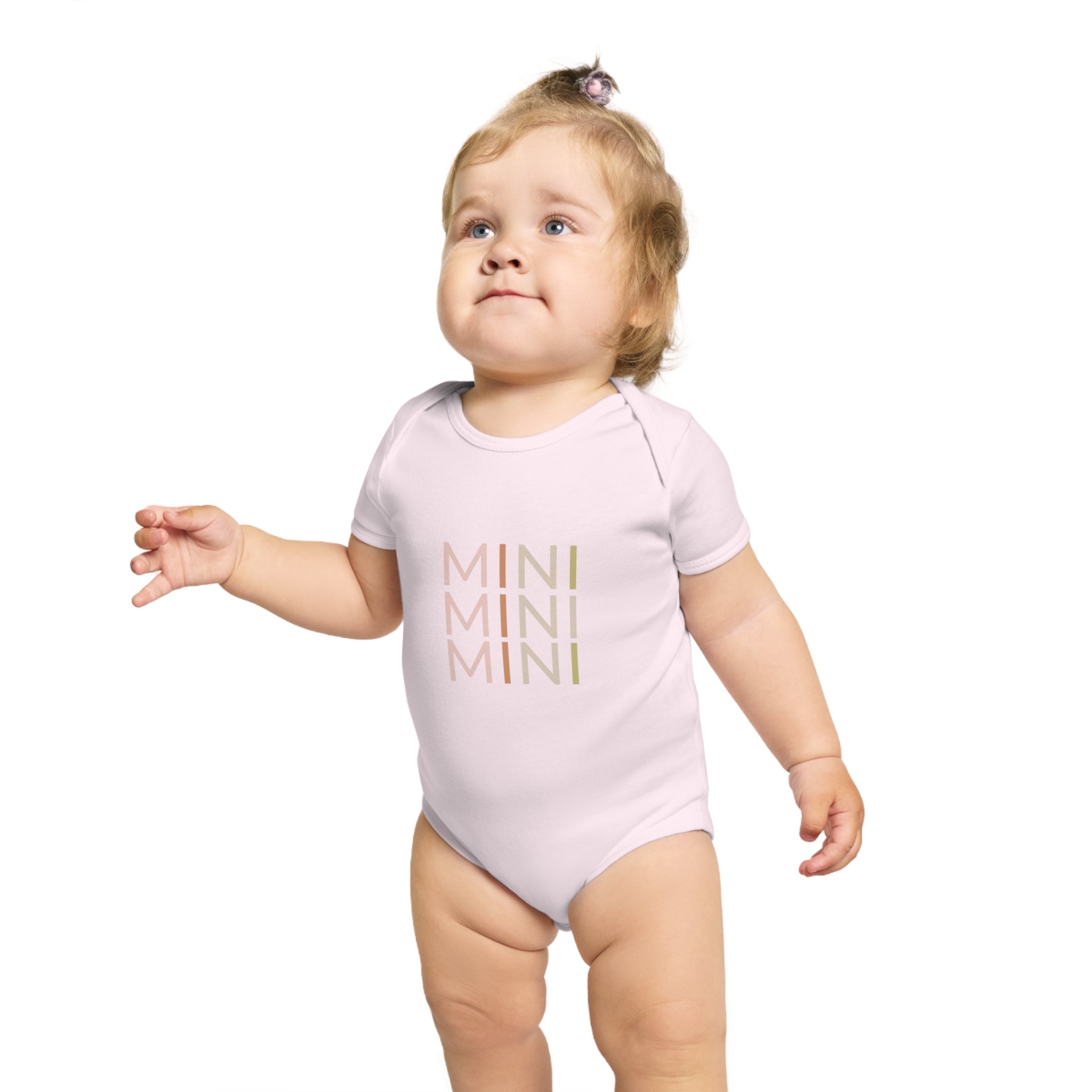 Cute little baby wearing a pink mini bodysuit